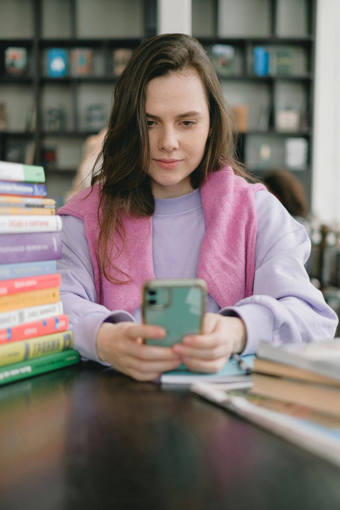 Jeune fille sur les réseaux sociaux entourés de livres.
